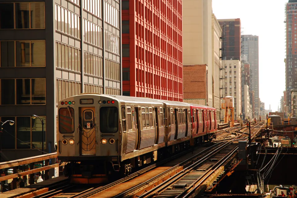 CHicago elevated train on track passing by tall buildings.